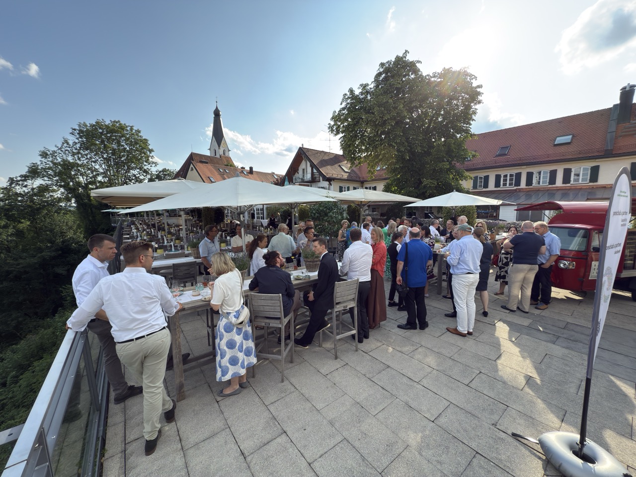 Das Bild steht in Zusammenhang mit Mediation und Konfliktlösung durch die Kanzlei Ponschab & Partner und zeigt folgendes: Eine Gruppe von Menschen steht draußen um Tische herum. Bei Fragen zu Konflikten und Konfliktlösung wenden Sie sich bitte an uns unter info@ponschab-partner.com