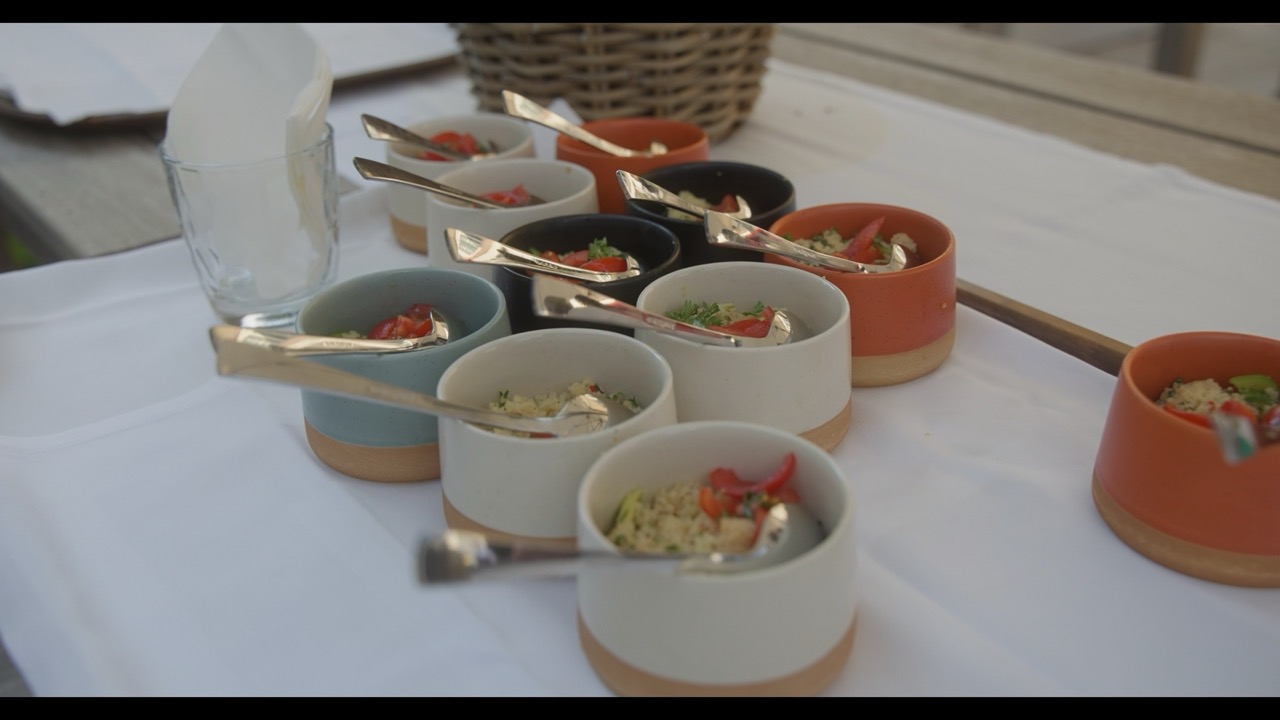 Das Bild steht in Zusammenhang mit Mediation und Konfliktlösung durch die Kanzlei Ponschab & Partner und zeigt folgendes: Auf einem weißen Tischtuch sind mehrere kleine Keramikschalen in verschiedenen Farben angeordnet, die jeweils eine Portion Essen und einen Metalllöffel enthalten. Im Hintergrund stehen ein Glas mit einer Serviette und ein Weidenkorb. Bei Fragen zu Konflikten und Konfliktlösung wenden Sie sich bitte an uns unter info@ponschab-partner.com