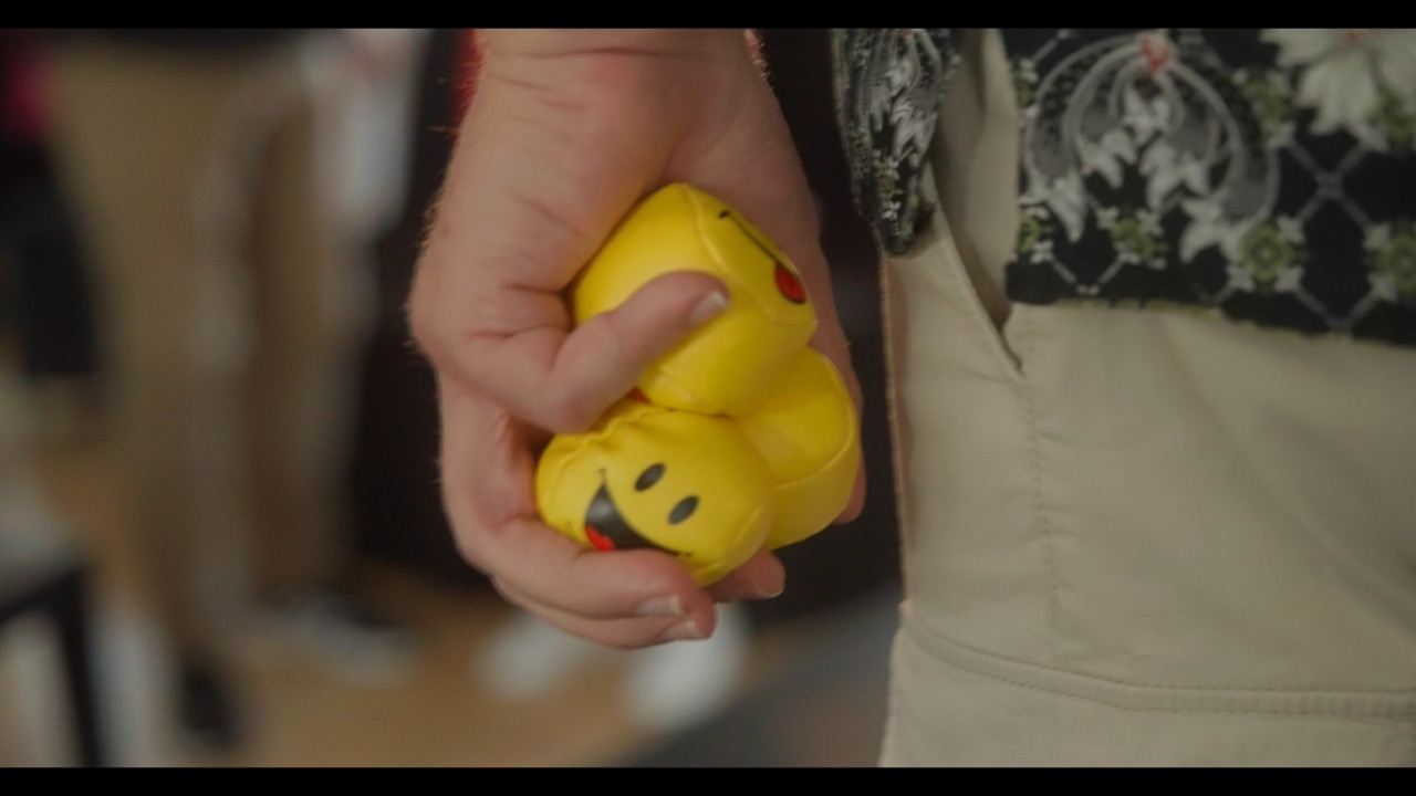 Das Bild steht in Zusammenhang mit Mediation und Konfliktlösung durch die Kanzlei Ponschab & Partner und zeigt folgendes: Eine Person, die eine beige Hose und ein gemustertes Hemd trägt, hält einen zerquetschten gelben Smiley-Stressball in der Hand. Der Hintergrund ist unscharf. Bei Fragen zu Konflikten und Konfliktlösung wenden Sie sich bitte an uns unter info@ponschab-partner.com